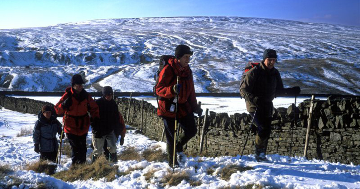 group of people walking in the Durham Dales during winter time with snow on ground.